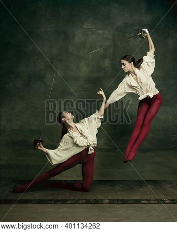Motion. Two Young Female Ballet Dancers Like Duelists With Swords On Dark Green Background. Caucasia
