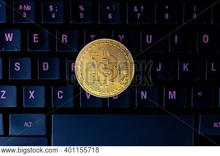 Bitcoin On Compuer Keyboard In Background, Symbol Of Electronic Virtual Money And Mining Cryptocurre