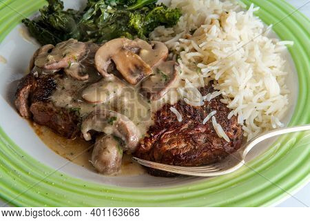Grilled Club Steak With Creamy Marsala Wine Mushroom Sauce And Sides Of Rice And Broccoli Rabe
