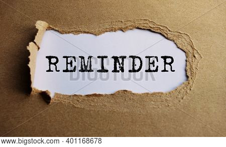 The Text Remider, Appearing Behind Torn Paper. The Craft Paper Is Ripped.
