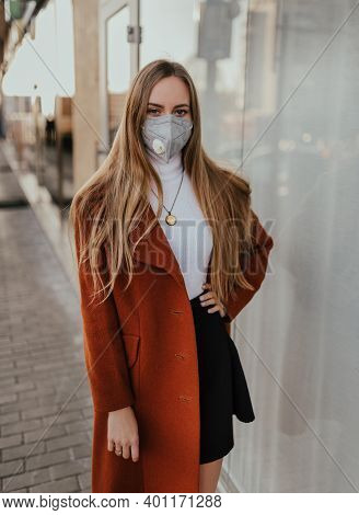 Young Ukrainian Blonde Woman In Protective Medical Mask Kn95 Respirator On Street Against Background