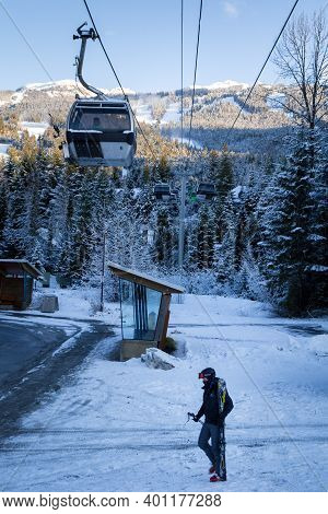 Whistler, Bc, Canada - Dec 27, 2020: Blackcomb Gondola With Skiier Walking In Front.