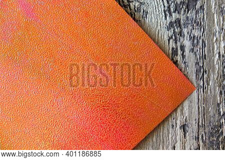 Embossed Orange Paper With  Holography And Serigraphy  Effect On Wooden Background