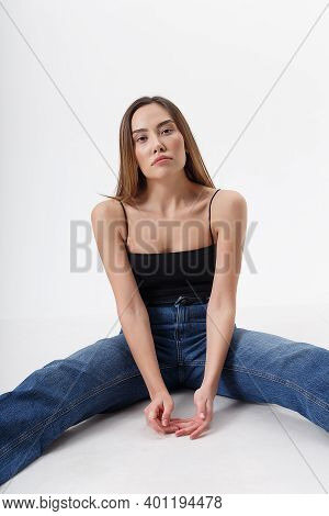 Young Attractive Asian Woman With Long Hair In Black Top, Blue Jeans Isolated On White Studio Backgr