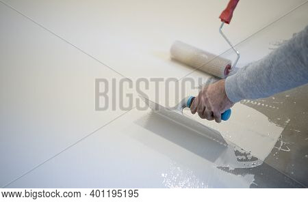 Worker Painting White Polyurethane Resin On Concrete Floor