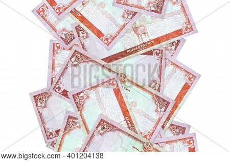 20 Nepalese Rupees Bills Flying Down Isolated On White. Many Banknotes Falling With White Copy Space