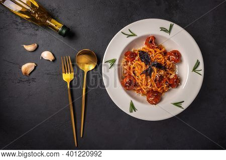 Pasta With Cherry Tomatoes, Cheese And Basil Served On Plate With Spoon, Fork And Olive Oil On Dark 