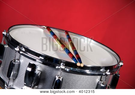 Silver Sparkel Snare Drum And Sticks Isolated On Red