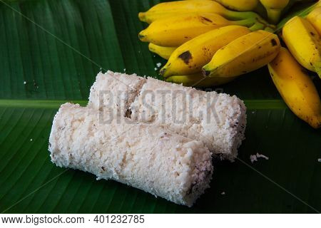Popular Steamed Kerala Breakfast Dish Served In Banana Leaf With Yellow Banana, Puttu And Yellow Sma