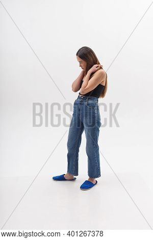 Young Attractive Asian Woman With Long Hair In Black Top, Blue Jeans Isolated On White Studio Backgr