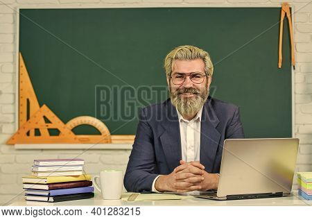 Teach And Inspire. Senior Teacher Sit At Desk. Bearded Man Back To School. Formal Education. Educati