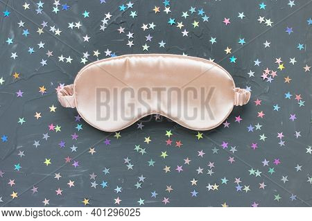 Pink Satin Eye Sleeping Mask And Sillver Stars Confetti On Dark Black Background. Sweet Dreams Conce
