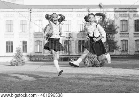 First Day Of Holidays. Happy Kids Run From School. Little Children In Midair Outdoors. School Holida