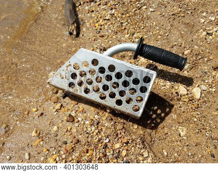Metal Scooper On Beach With Sand And Rocks