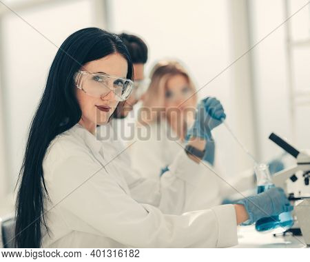 Close Up.modern Woman Sitting With Colleagues At The Laboratory