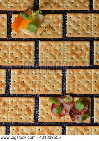 Conceptual Slices Of Salami And Cheese On Crackers With Salt