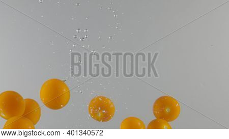 Berries Fall Into Water On Isolated Background. Action. Juicy Berries Fall Into Water With Bubbles. 