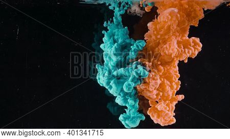 Splash Of Colored Ink In Water On Black Background. Action. Two Colors Are Mixed In Water On Isolate