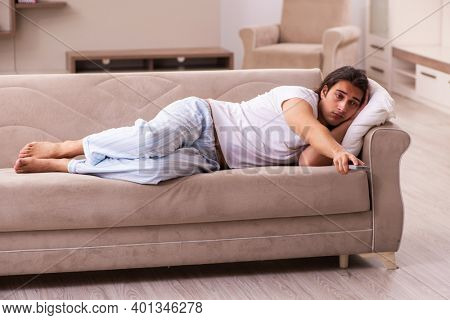 Young lazy man in oversleeping concept at home