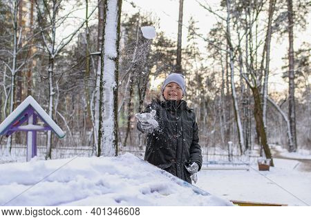 Cheerful Caucasian Boy In Winter Clothes Dressed A Snowball Maker On His Head And Smiling In A Winte