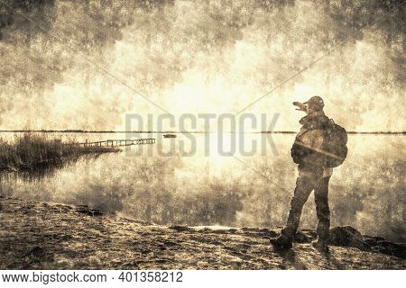 Exhilarated Man Standing On Rocky Coast At Lake. Traveler With Backpack Watch The Horizon.  Calotype