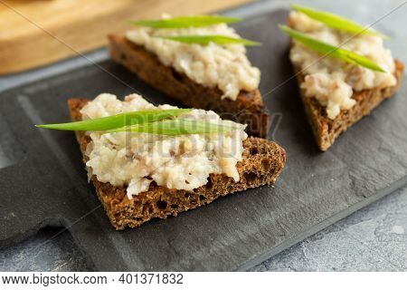 Three Toasts Or Canapes With Herring Forshmak On A Tapas Board. Forshmak On Rye Bread Canape With Gr