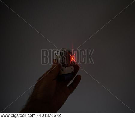 Male Hand Holding Futuristic Safety Home Laser Beamer Security Alarm Device With Red Laser Light In 