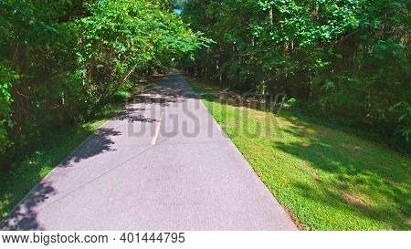 Paulding County, Ga Usa - 06 11 20: Paved Trail Side Ahead View With Green Foliage In The Summer Sil
