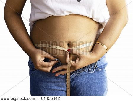 Mid Section Of An Indian Woman Measuring Fat Belly With Tape On White Background