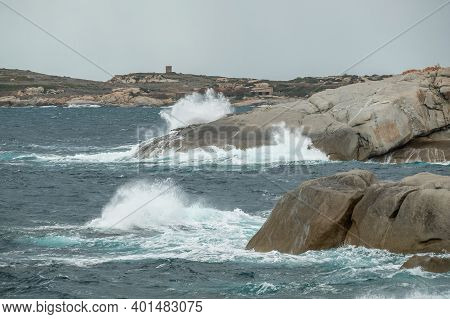 Stormy Mediterranean Sea Crashing Onto The Rocky Coastline At Punta Caldanu In The Balagne Region Of