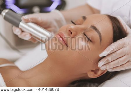 Gorgeous Happy Young Woman With Perfect Skin Smiling With Her Eyes Closed, Getting Facial Treatment 