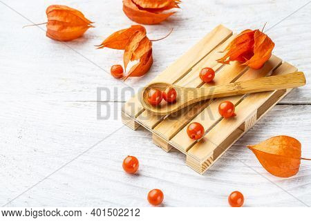 Red Physalis Flower And Fruit On The White Woden Background. Banner, Catering Menu Recipe Place For 