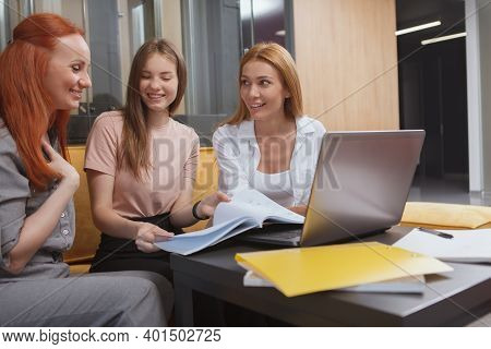 Cheerful Businesswomen Laughing, Using Laptop Together At The Office