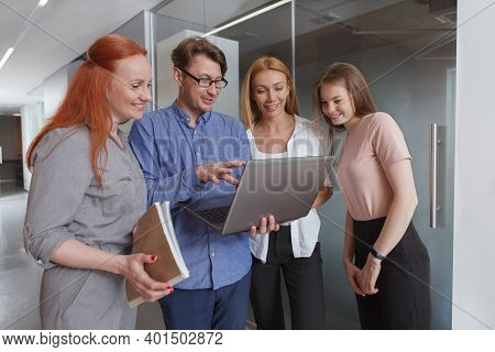 Experienced Businessman Showing Something On His Laptop To Female Colleagues