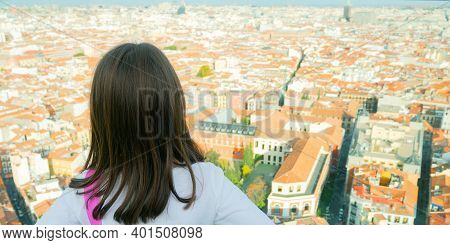 The Picture Shows A Back View Of A Little Girl Looking At The Skyline Of The City Of Madrid On A Sun