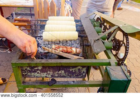 Traditional Hungarian Spit Cinnamon, Chimney Cake Is Rotate For Equal Baking Over Glowing Charcoal E