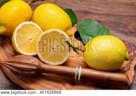 Fresh Ripe Yellow Italian Lemons And Wooden Juice Squeezer, New Harvest
