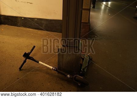 Electric Scooter Lying Down On Sidewalk In Dark Evening. Problem Of Share System Rules. Zurich, 19. 