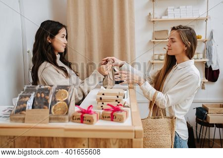 Female Customer Making A Purchaise, Recieving Goods On The Bag From A Shopkeeper