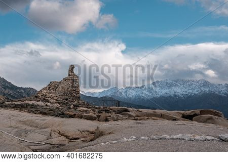 Ancient Genoese Tower At Punta Caldanu Near Lumio In The Balagne Region Of Corsica With The Snow Cap