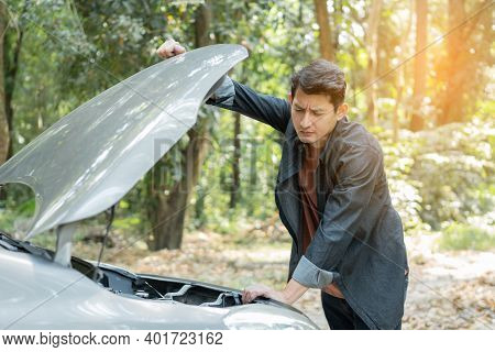 Man Open Car Hood For Repair As Maintenance Service. Man Trying To Repair A Car Engine, Looking Insi