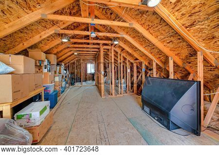 Interior Of The Attic Of House With Boxes And Old Appliances Under Gable Roof