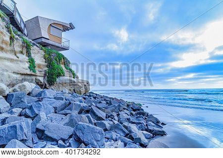 Building On Rocky Cliff With Ocean And Cloudy Sky Views In San Diego California