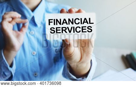 Business Woman Sitting At A Table In A Light Office Holding A Business Card. The Content Of The Lett
