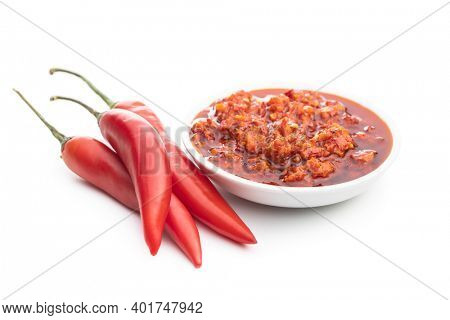 Red hot chili paste in bowl and chili peppers  isolated on white background.