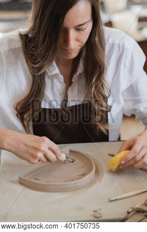 Close-up Of A Master Potter, Clay Cutting Special Tool. Female Artist Cutting With A Wooden Loop Too