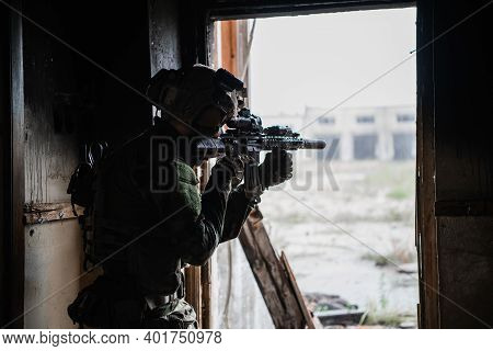Military Soldier In The Form Holds In The Hands An Assault Rifle, Check Possible Enemies Around The 