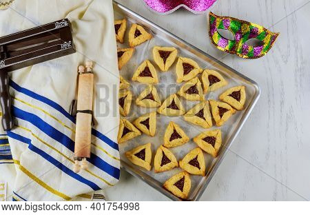 Jewish Triangle Cookies With Jam For Purim With Mask, Tallit And Noisemaker With Tora.