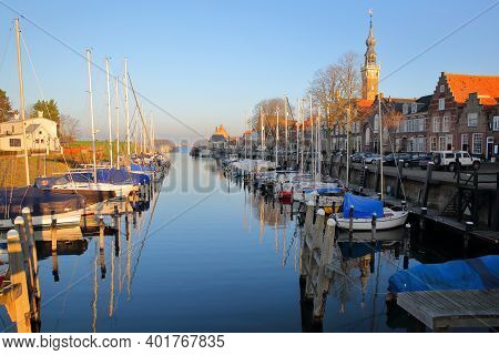 Veere, Netherlands - December 10, 2020: The Marina (harbor) And Historic Buildings With The Clock To