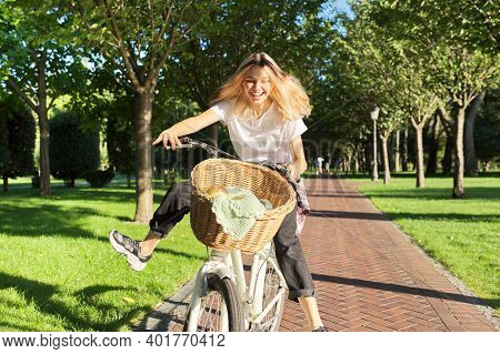 Happy Young Woman Riding Bike On Road In Park, Beautiful Hipter Teenager Having Fun And Laughing.